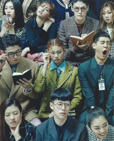 a group of people sitting next to each other in front of a crowd holding books