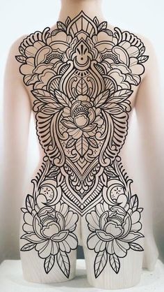 the back of a woman's body with intricate designs on it