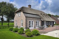 a small brick house with a thatched roof