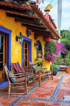 an outdoor patio with chairs and potted plants on the outside wall, along with colorful tile flooring