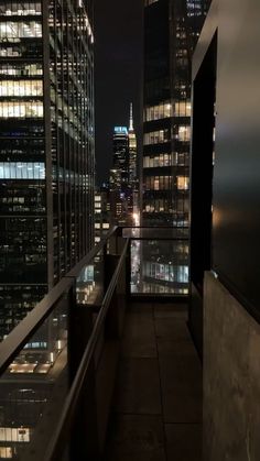 the city skyline is lit up at night with skyscrapers in the foreground and lights on