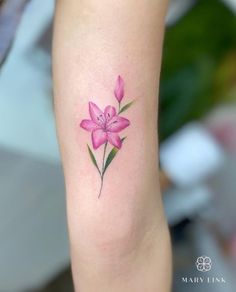 a pink flower tattoo on the arm