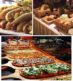 there are many different types of food on the table and in the background is an assortment of pizzas