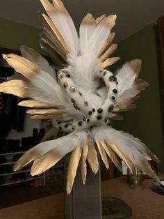 a vase with feathers and beads in it