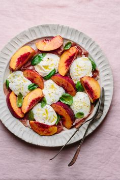 a white plate topped with sliced peaches and mozzarella