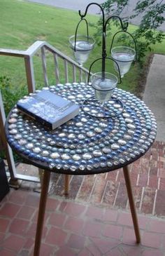 a table with two glasses and a book on it sitting in front of a window