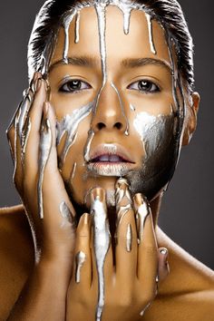 a woman with white paint on her face and hands