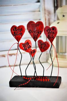 a group of red hearts sitting on top of a black stand next to each other