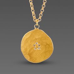 A tiny ring of five white diamonds sparkle in the center of a free-form, organically hammered 22k gold disk. Hangs on 14k gold chain. Pendant measures approximately 1/2 inch diameter. Matte finish. Hand Forged Gold Round Disc Jewelry, Gold Disk Necklace, Wedding Ring Redesign, Capsule Jewelry, Ring Redesign, Gold Chain Pendant, Disk Necklace, Hammered Jewelry, Gold Disc Necklace