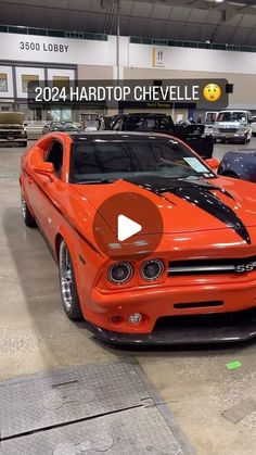 an orange car parked in a garage next to other cars