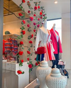 there is a display in the window of a clothing store with red roses on it