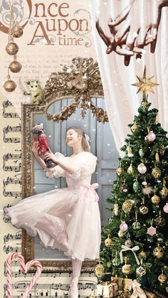 a woman in a white dress is holding a red christmas ornament