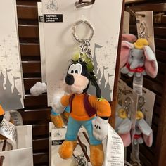 a mickey mouse keychain hanging from the side of a shelf in a store