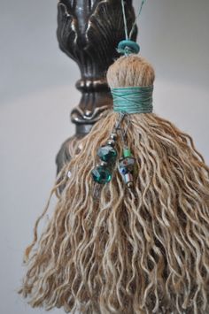 a close up of a tassel hanging from a light fixture with beads on it