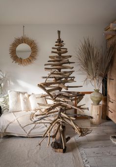 a christmas tree made out of driftwood in a living room next to a couch