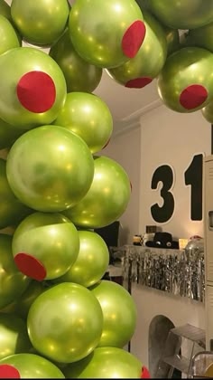 green and red balloons are hanging from the ceiling