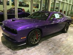 a purple sports car is on display in a showroom