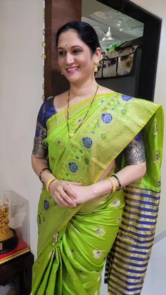 a woman wearing a green sari and gold jewelry