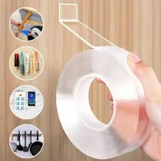 a hand holding a roll of clear adhesivee tape with various items around it