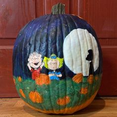 a painted pumpkin sitting on top of a wooden floor