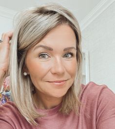 a woman with blonde hair is looking at the camera while she has her hand on her head