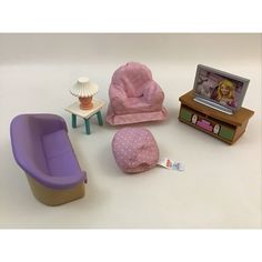 there is a doll house furniture set on the floor with a tv and chair in front of it