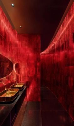 a bathroom with red walls and sinks