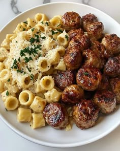 a white plate topped with pasta and meatballs