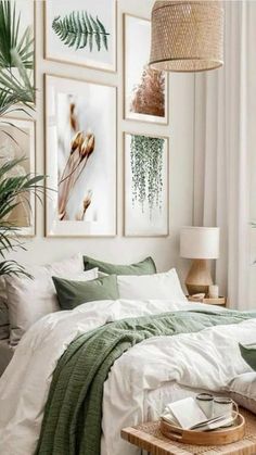 a bedroom with white walls and green bedding, pictures on the wall above the bed