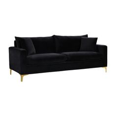 a black velvet couch with gold legs and pillows on the back, against a white background