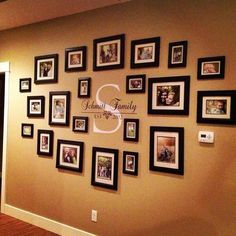 a wall with many pictures on it and the words family is displayed in black frames