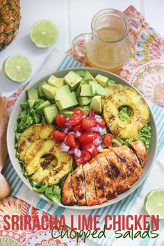 a salad with grilled chicken, avocado, tomatoes and sliced pineapples