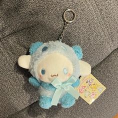 a blue teddy bear keychain with a tag hanging from it's side