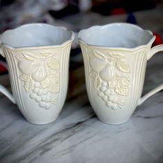 two white cups sitting on top of a table