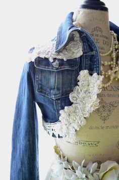 a mannequin wearing a jean jacket with lace and flowers on it's chest