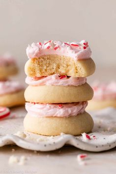 three cookies stacked on top of each other with pink frosting and sprinkles