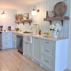 a kitchen with white cabinets and wood floors