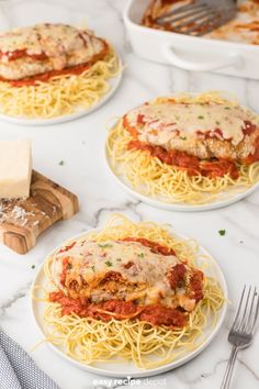 three plates of spaghetti with meat sauce and cheese on the side next to a cutting board