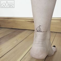 a small sailboat tattoo on the ankle