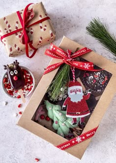 an open gift box sitting on top of a table next to a small christmas tree