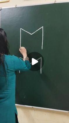 a woman writing on a blackboard with chalk