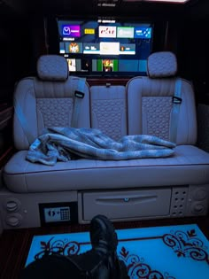 the interior of a car with two seats and a blanket on top of it in front of a television