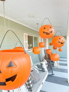 some pumpkins hanging from the side of a house with jack - o'- lanterns on them