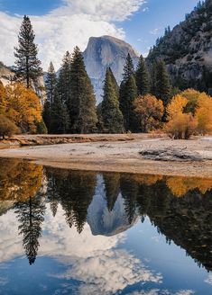 the mountains are reflected in the still water