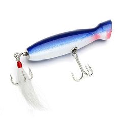 a blue and white fishing lure sitting on top of a fish hook with a red tail