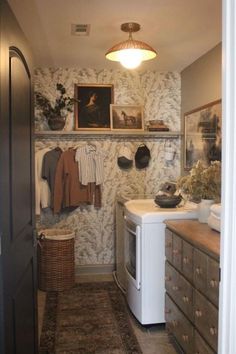 a washer and dryer sitting in a room next to a wall with pictures on it