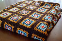 a crocheted blanket sitting on top of a wooden table