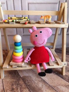 a pink stuffed animal sitting on top of a wooden chair next to a stack of toys