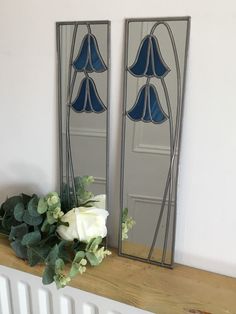 two mirrors with flowers on the mantle in front of each other next to a radiator