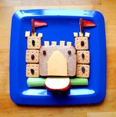 a blue plate topped with food on top of a wooden table next to a red apple